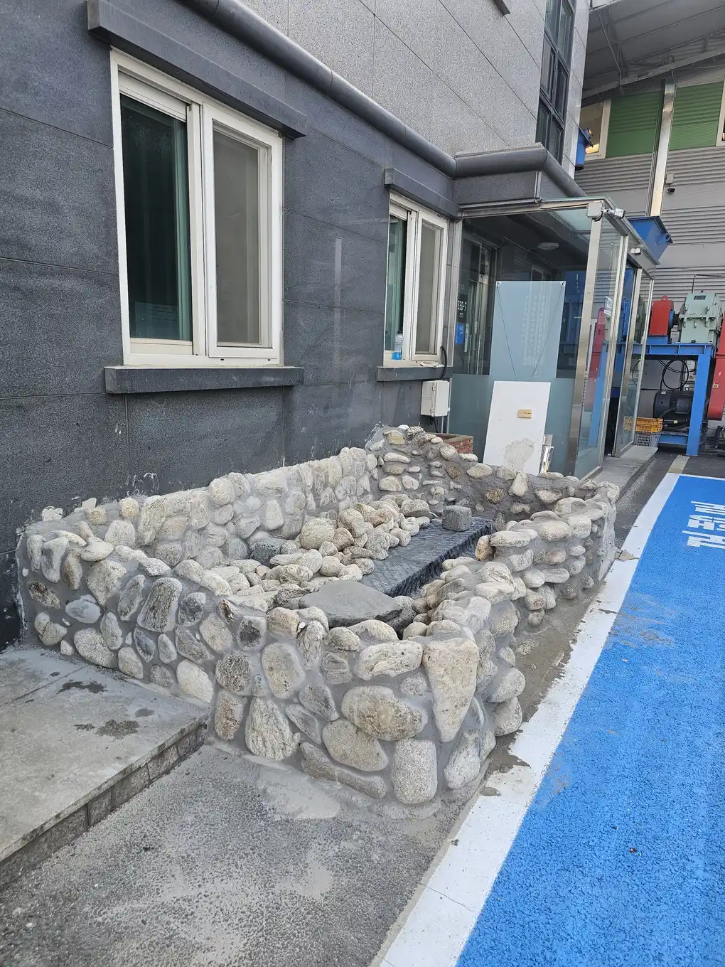 건물 입구 연못 리모델링 중 돌 마감 측면