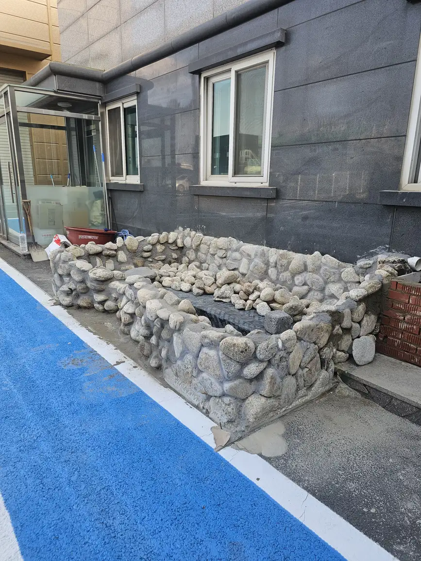 건물 입구 연못 리모델링 중 돌 마감 정면